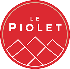 Logo circulaire rouge avec le texte « Le Piolet » en blanc. Sous le texte, on retrouve un dessin stylisé ressemblant à une série de pics montagneux délimités en blanc.